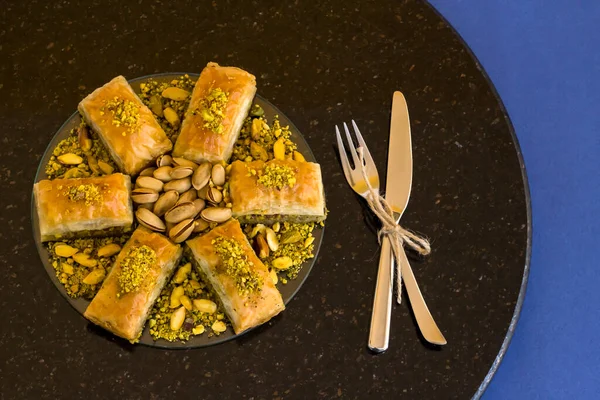 土耳其传统甜点Pistachio Baklava 深色大理石桌上 蓝色表面 顶部视图 — 图库照片