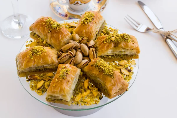 传统的土耳其糕点甜点在白色的Pistachio Baklava与土耳其咖啡 餐具和一杯水 — 图库照片