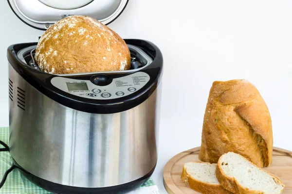 Professional but household bread making machine on white with bread.