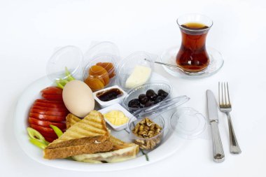 Geleneksel Türk Kahvaltı Tabağı, kaynamış yumurta ve beyaz yüzeyde çay.