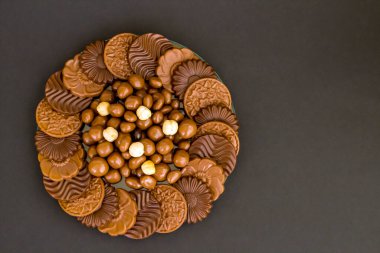 Sütlü ve sert yuvarlak çikolatalı Madlen, cam tabakta, fındıklı olarak tasarlandı. Şeker Şöleni veya herhangi bir festival kutlaması.