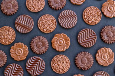 Sütlü ve sert yuvarlak çikolatalı Madlen, siyah arka plan üzerine dizayn edilmiş. Şeker Şöleni ya da herhangi bir festival kutlaması..