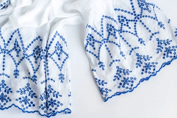 Mavi işlemeli beyaz bayanlara yazlık bluz beyaz yüzeyde fotokopi alanı, üst görünüm