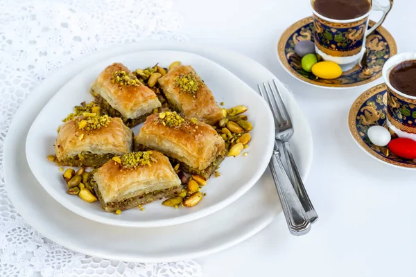 Geleneksel Türk Pastası Tatlısı Pistachio Baklava beyaz üzerine Türk Kahvesi ve çatal bıçak takımı.