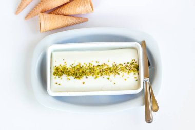 Fıstık tozu, çatal bıçak seti ve korseyle geleneksel Türk dondurması Maras.