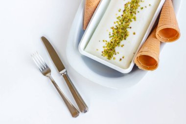 Fıstık tozu, çatal bıçak seti ve korseyle geleneksel Türk dondurması Maras.