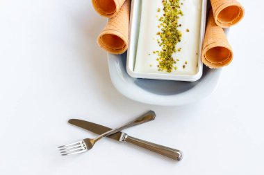 Fıstık tozu, çatal bıçak seti ve korseyle geleneksel Türk dondurması Maras.