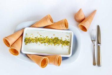 Fıstık tozu, çatal bıçak seti ve korseyle geleneksel Türk dondurması Maras.