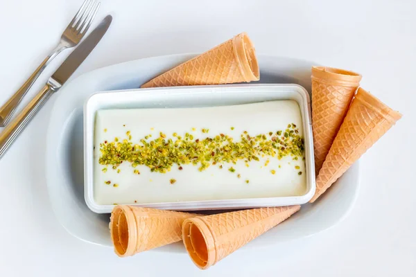 Fıstık tozu, çatal bıçak seti ve korseyle geleneksel Türk dondurması Maras.