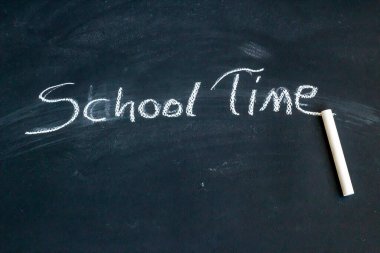 Tahtaya beyaz tebeşirle yazılmış okul zamanı, üst görünüm