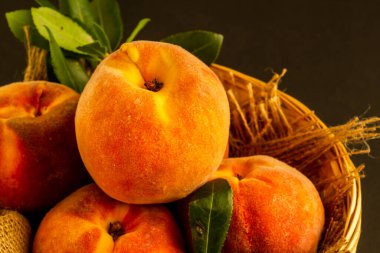 Taze, olgun şeftaliler karanlık yüzeyde sepetin içinde fotokopi alanı var.