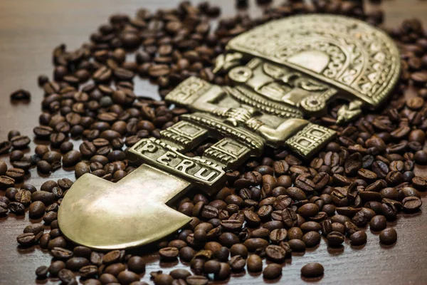 Kahve torbadan masaya dökülüyor. Arabica ve robusta koyu bir ahşap masada. Kahverengi renk. Kahve çekirdekleri yüzeye saçılmış. Mesajı yerleştir. Peru Tanrısı. Peru tanrı biblosu