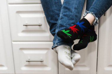 Sevgililer mutfakta oturur ve ayaklarına dokunurlar. Yanında bir kız olan bir adam. Bacakları marihuana görünümlü kot pantolon ve çorap giyiyor. Gürültü ekledim. Yakın plan.
