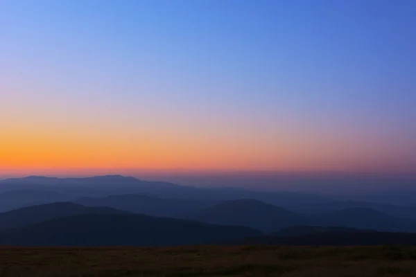 Los primeros o últimos rayos del sol en un paso de montaña. Mañana y tarde en la naturaleza. Colorido atardecer y amanecer sobre las colinas de la montaña. Cárpatos en verano y otoño. Fotos de stock