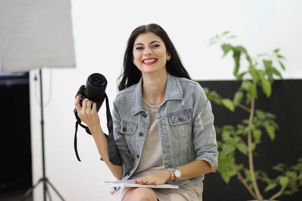 Beautiful young women keeping professional camera in her hands — Stock Photo, Image