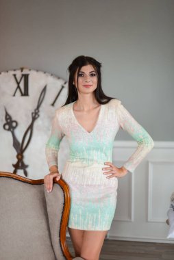 Noel ağacının yanında duran güzel genç bayan ve büyük saat.