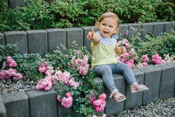 Baby-Mädchen vor Spielplatz lacht in Blumen — Stockfoto