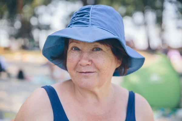 Şapka giyen yaşlı kadın rahat ve mutlu dışında — Stok fotoğraf