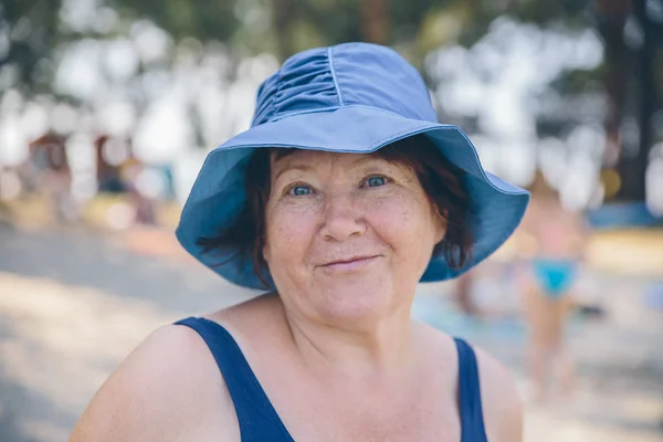 Старшая женщина в шляпе расслабленной и счастливой снаружи — стоковое фото