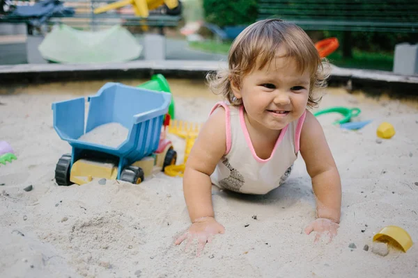 Bébé fille dans bac à sable jouer avec des jouets — Photo