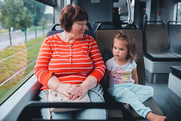 Senior grandmother with baby commuting by tram Stock Photo