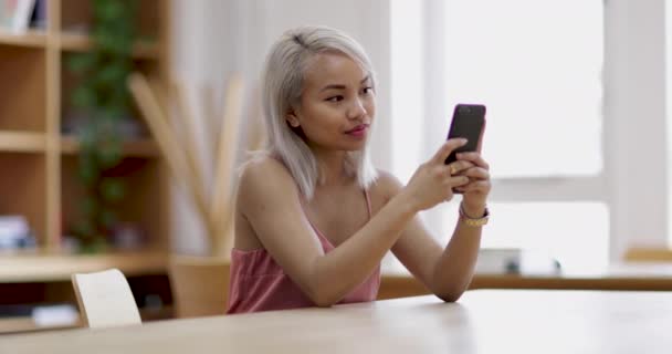 Junge erwachsene Frau nutzt Smartphone im College — Stockvideo