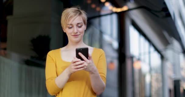 Молодая женщина смеется над смартфоном — стоковое видео