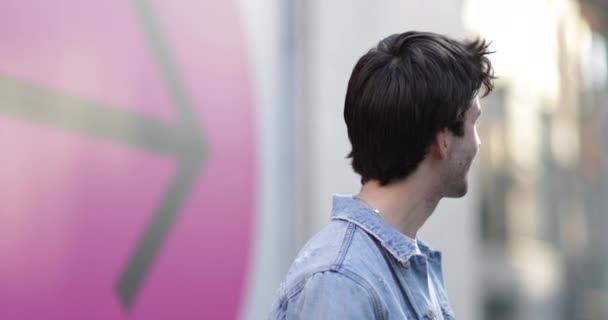 Portrait of young adult male with arrow sign in background — Stock Video