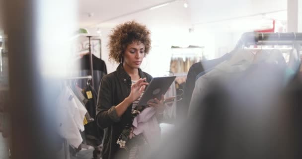 Store manager using digital tablet in a clothing store — Stock Video