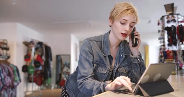 Digitális tábla segítségével egy ruhaüzlet üzletvezető — Stock videók