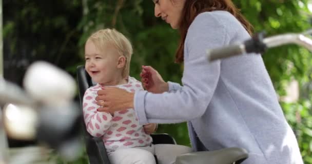 Madre Levantando Niño Del Asiento Bicicleta — Vídeo de stock