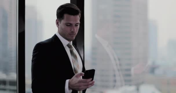 在摩天大楼办公室使用智能手机的商人 — 图库视频影像