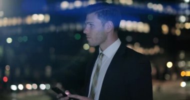 İşadamı Smartphone açık havada bokeh etkisi ile gece kullanarak.