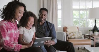 Afro-Amerikan aile dijital tablet evde video izlerken