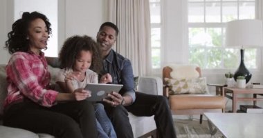 Afro-Amerikan aile dijital tablet evde video izlerken