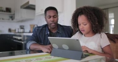 Afrikalı-Amerikalı babası kızı dijital tablet kullanarak ev ödevlerinde yardım