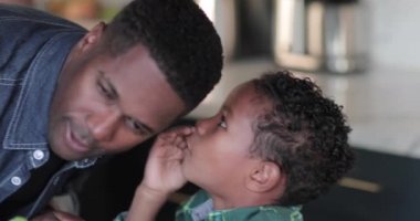 Afro-Amerikan çocuk babaları kulağına fısıldayan