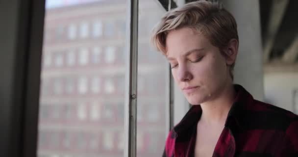 Mujer Joven Mirando Por Ventana Apartamento Loft Pensando — Vídeos de Stock