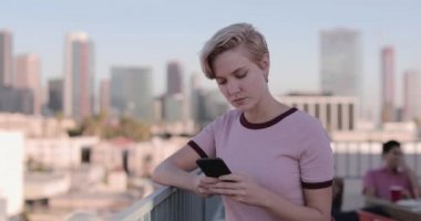 Genç yetişkin kadın bir çatı partide bir smartphone kullanarak