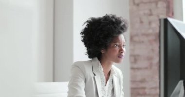 Bir kadın Afro-Amerikan iş yürütme bir masaüstü bilgisayarda bir ofiste çalışan portre