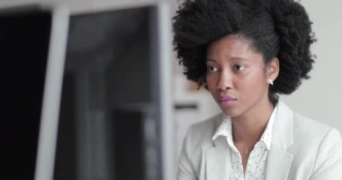 Bir masaüstü bilgisayarda bir ofiste çalışan kadın Afro-Amerikan iş yürütme