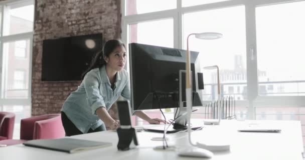 デスクトップ コンピューター上の若い成人女性作業し ビューを見て — ストック動画