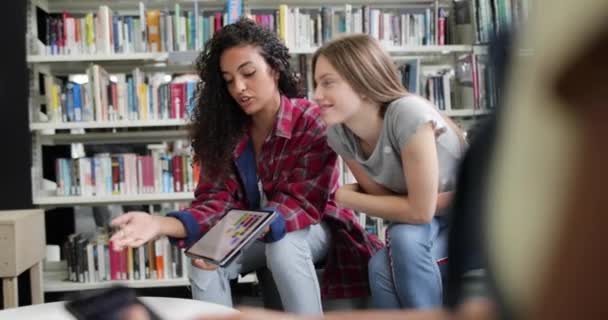 デジタル タブレットで図書館で一緒に勉強する高校生 — ストック動画