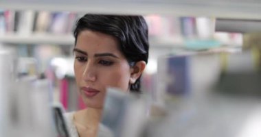 Arap kız öğrenci Kitaplığı'nda kitap seçimi