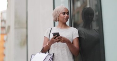 Bir alışveriş gezisi bir akıllı telefon kullanan Müslüman kadın