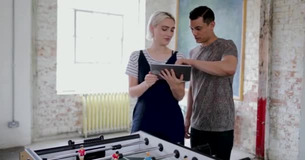 Jeunes adultes utilisant une tablette numérique dans un bureau créatif 