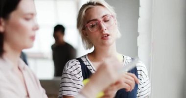 Genç yetişkinler yapışkan notlar ile yaratıcı bir ofiste planlama