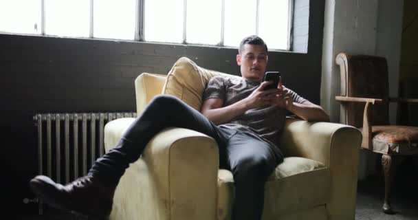 Millennial Usando Smartphone Apartamento Tipo Loft — Vídeo de stock