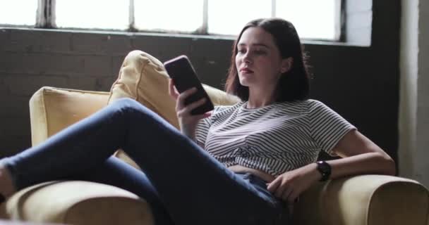 Χιλιετή Χρησιμοποιώντας Smartphone Ένα Διαμέρισμα Σοφίτας — Αρχείο Βίντεο