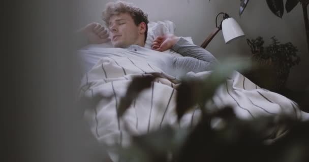 Ung Vuxen Man Kontrollera Smartphone När Han Vaknar Upp Morgonen — Stockvideo